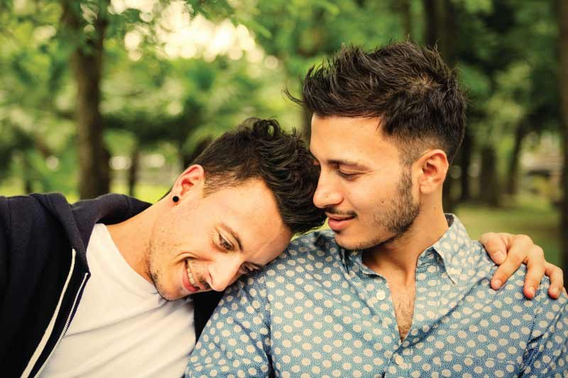 couple hugging and sitting on park bench